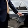 A private driver opening the door of a luxury sedan
